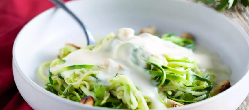 Zucchini spaghetti with grilled hazelnuts and emmental sauce