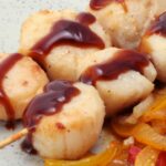 Scallops on a skewer and its warm vinaigrette