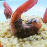 Sage-cooked prawn bites on curry risotto