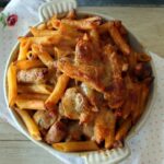 Penne gratin with chipolatas and mushrooms