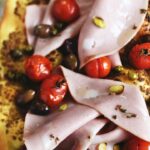 Pizza with mortadella tapenade with pistachios and cherry tomatoes