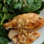 Grilled chicken cutlet with spinach, mustard sauce and onions