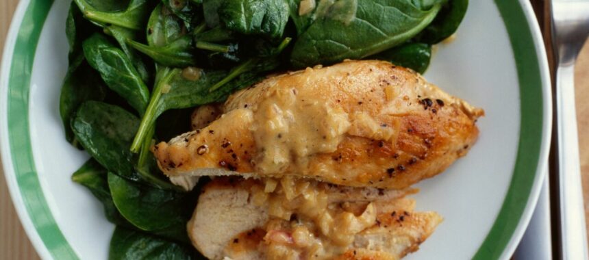 Grilled chicken cutlet with spinach, mustard sauce and onions